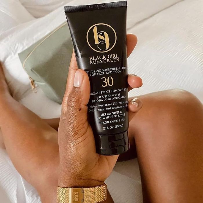 Person holding the Black Girl Sunscreen bottle with SPF 30