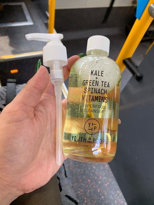 Someone holding a bottle of Youth To The People Superfood Cleanser, enriched with kale and green tea.