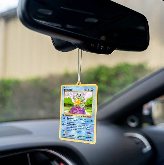 A Squirtle Pokémon card hanging from a car’s rearview mirror