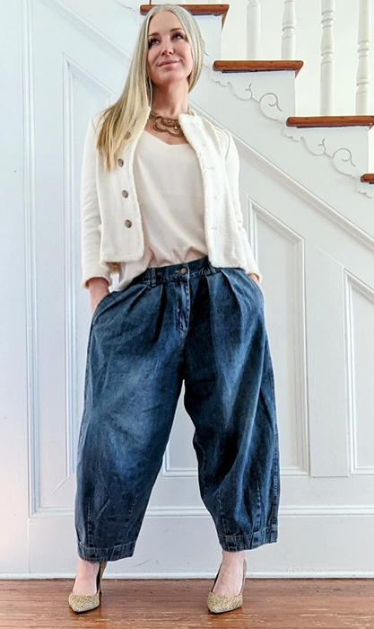 another reviewer wearing denim pants styled with a white sweater set and heels