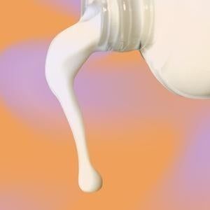 A bottle dispensing some of the milky toning lotion