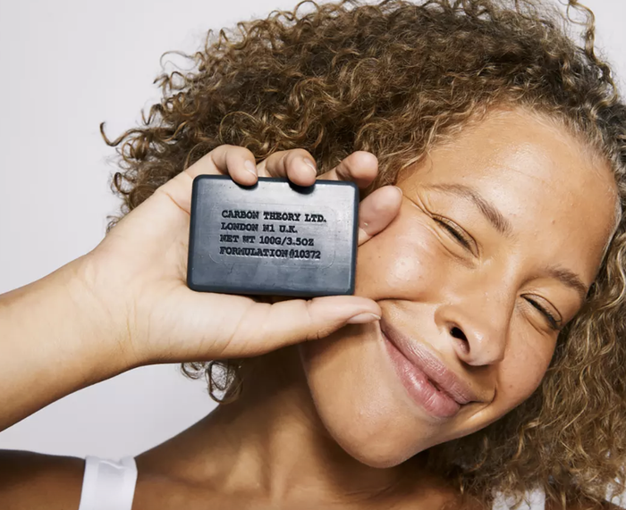 A model showcasing the cleansing bar in hand.