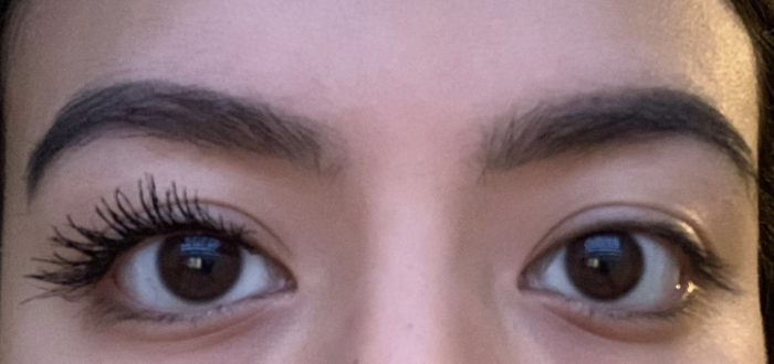 Customer applying mascara on one eye