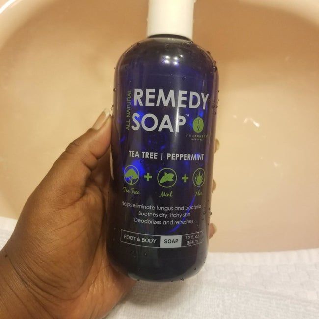 A reviewer holding the Remedy Soap bottle in their hand.
