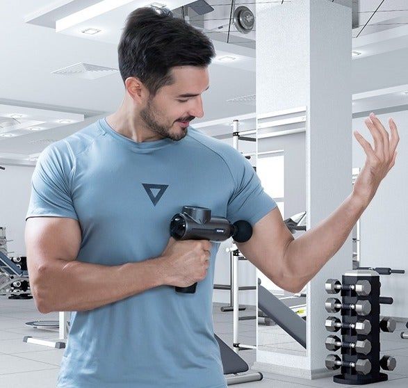 A model using the massage gun on their arm