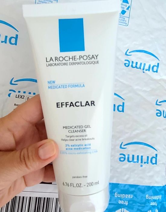 A reviewer holding a bottle of La Roche-Posay medicated gel cleanser