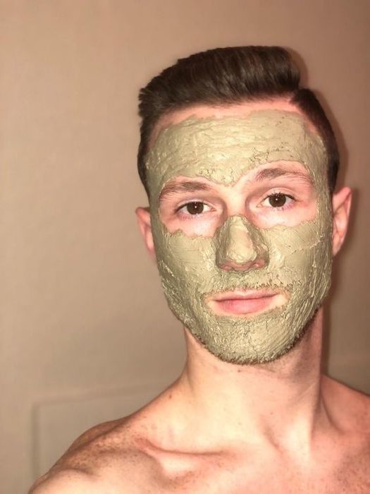 A reviewer is seen applying Aztec Secret Indian Healing Clay Mask to their face.