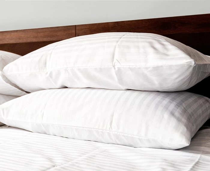two fluffy pillows stacked neatly on a bed