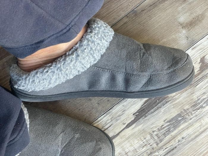 Reviewer showing the side of the grey slippers