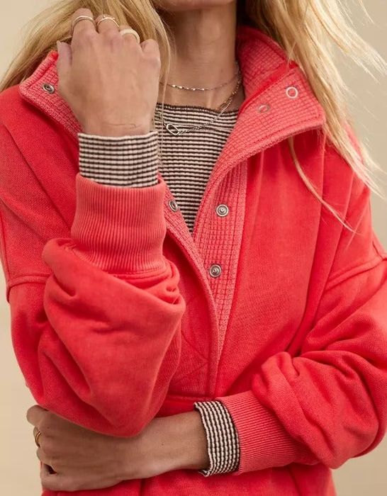 A person dressed in a layered, casual outfit, featuring a textured, buttoned jacket over a striped shirt, showcasing a stylish yet cozy ensemble.