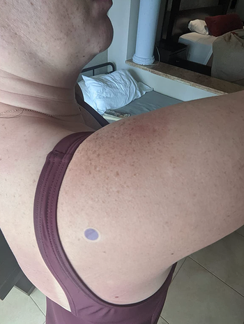 Reviewer showing a purple sticker on their arm