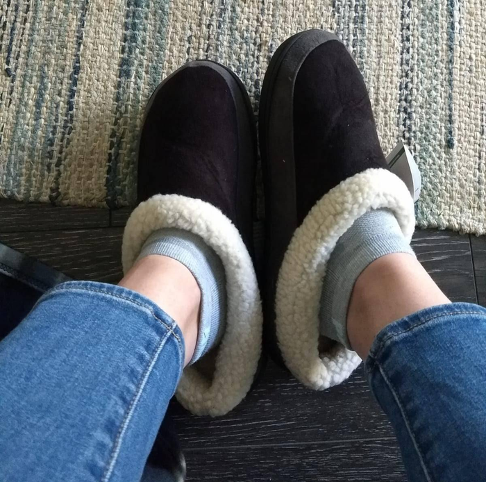 Reviewer wearing black slippers with a grey lining