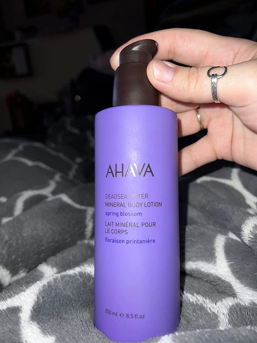 a reviewer holding the Dead Sea water body lotion bottle