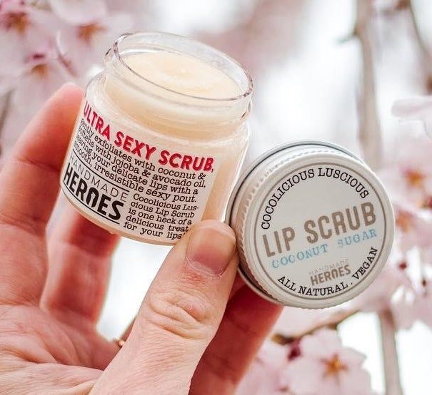 A hand holding the jar of lip scrub