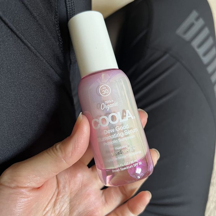 image of a hand holding the Coola serum bottle