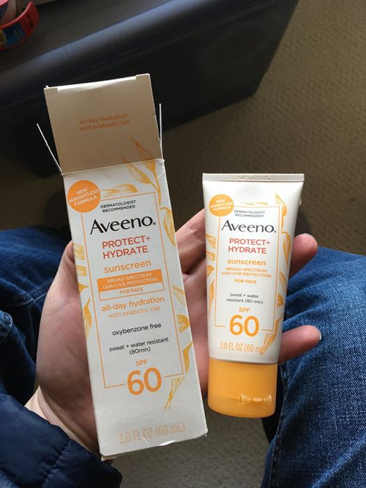 reviewer holding the sunscreen up