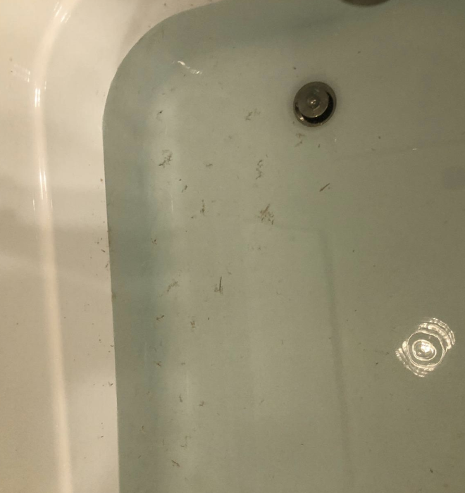 A review photo showcasing dirty bath water after using the exfoliating towel