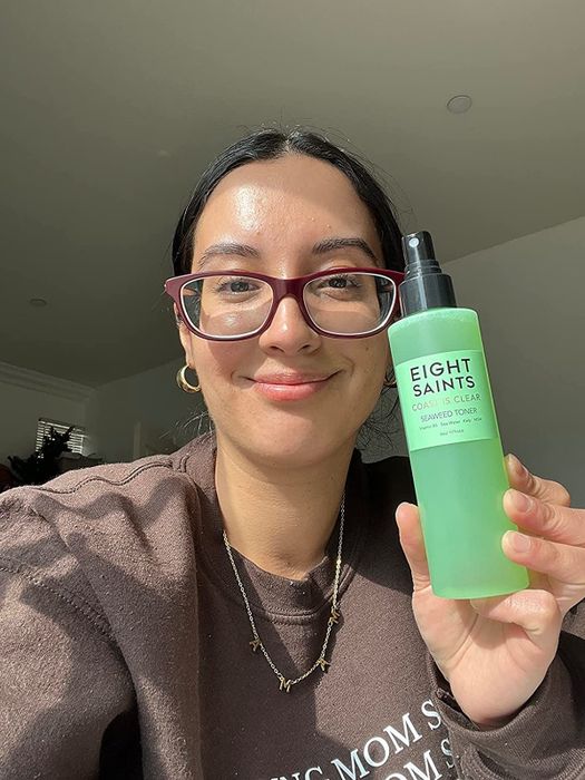 Image of a reviewer with clear skin holding the toner