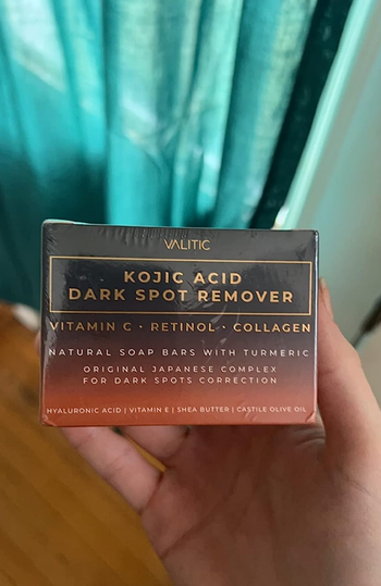 A reviewer pictured holding the soap bar in their hand