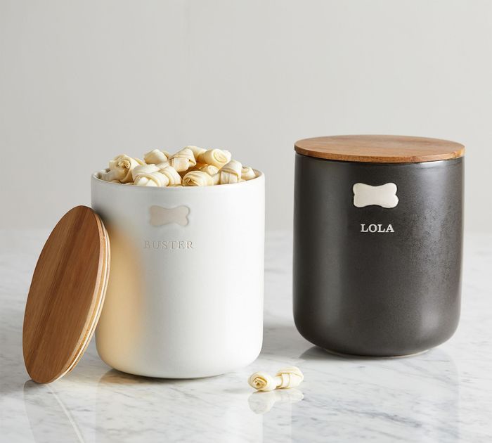 One canister in black and another in white, each featuring monogrammed pet names.