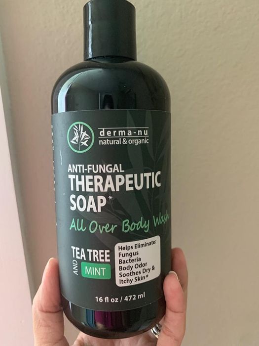 An image of a reviewer holding up the bottle of body wash