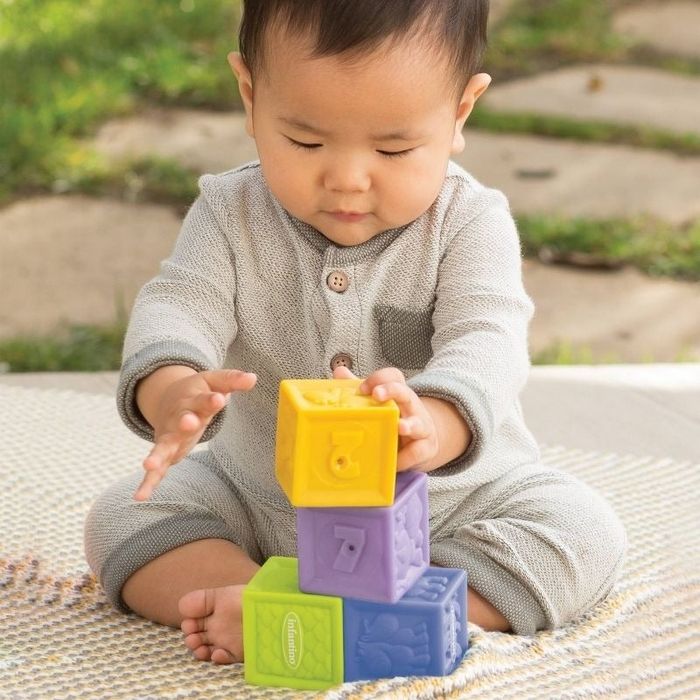 A baby plays with colorful blocks, stacking and exploring.