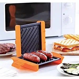 The open panini press with sausages sizzling inside.