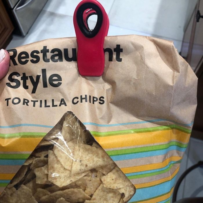 A bag of restaurant-style tortilla chips, sealed with a red clip. The packaging features the labels 'Non-GMO Project Verified' and 'Tortilla Chips.'