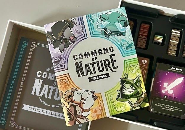 Unboxed board game "Command of Nature" featuring a rule book, a deck of cards, and various game components. Perfect for enthusiasts of strategic gameplay.