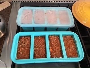 A reviewer displays two trays filled with stew—one with the lid securely on and the other with it removed.