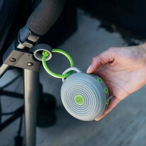 The portable sound machine is attached to a stroller, providing calming noise on-the-go.