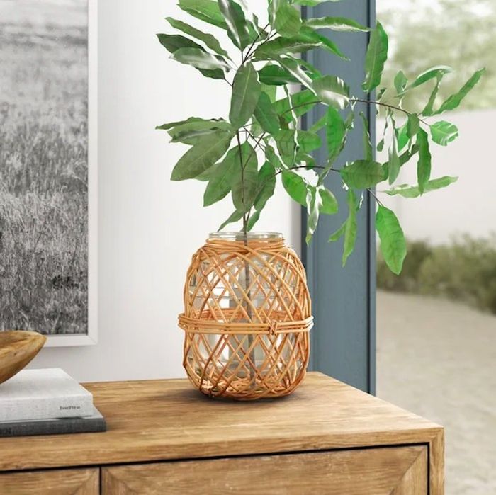 A vase with a leafy branch sitting gracefully on a console table.