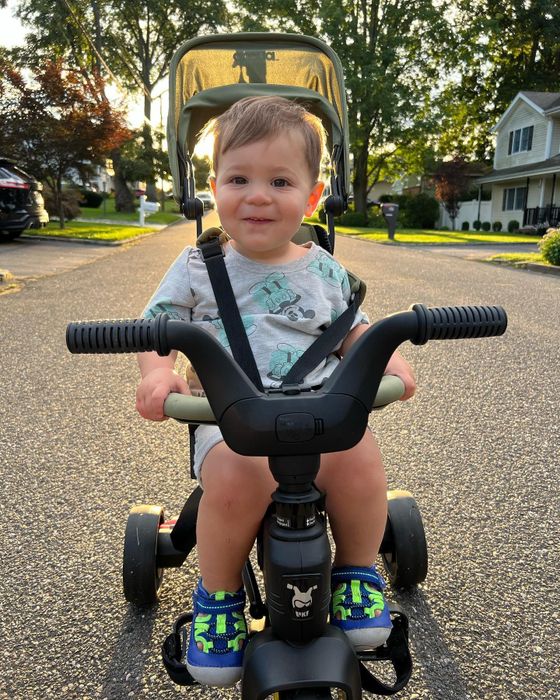 editor's son riding a green Doona Trike