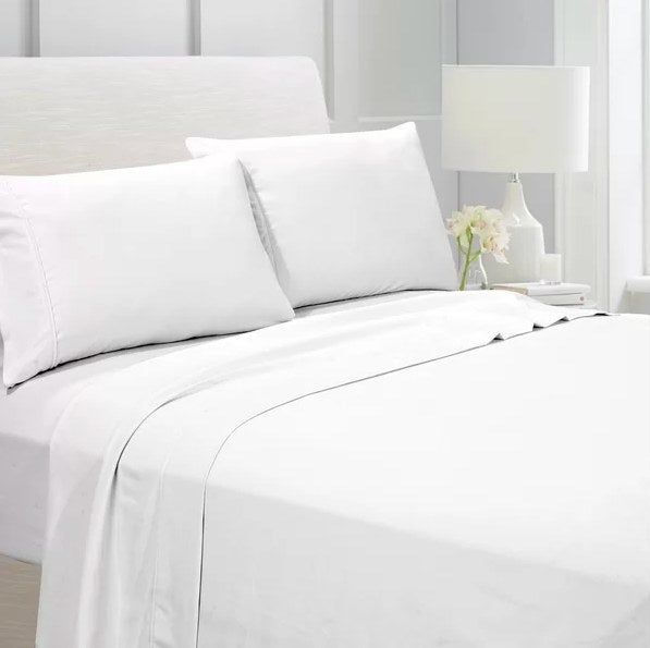 A white sheet set placed neatly on a bed.