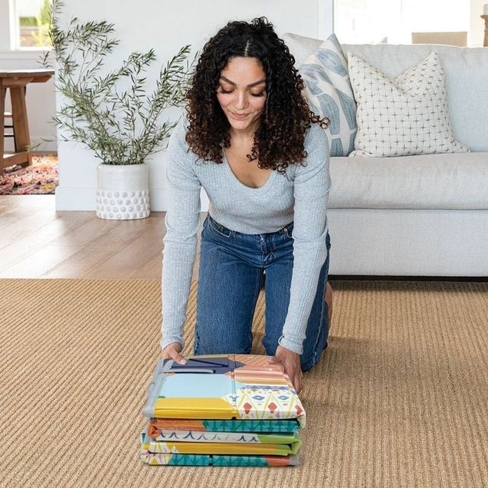 Adult packs up the play mat