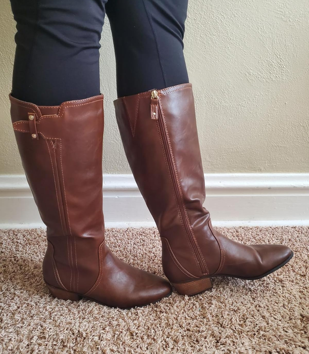 reviewer showcasing the brown Dr. Scholl's riding boots