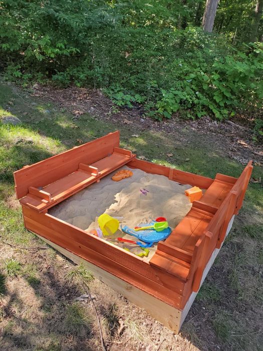 an outdoor sandbox with built-in benches for seating