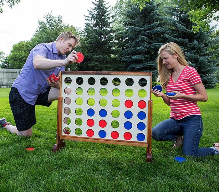 Two adults enjoying a game of oversized Connect Four.