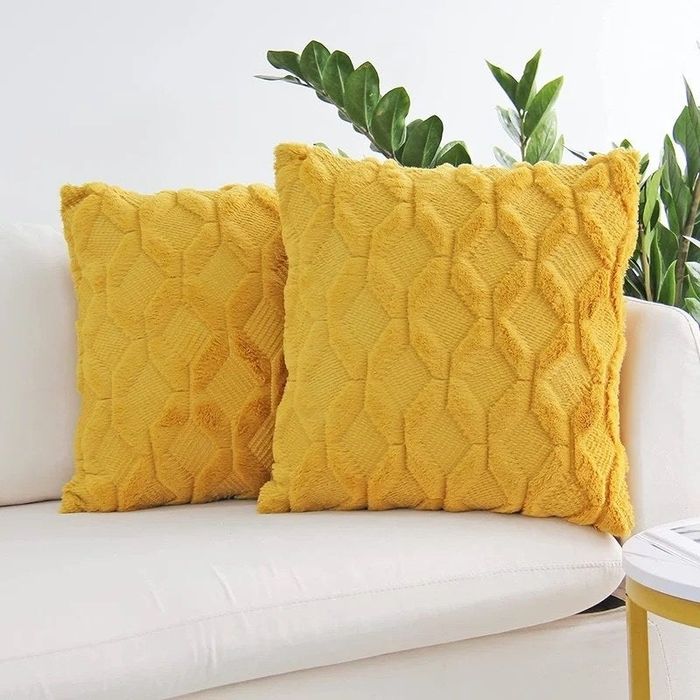 A set of yellow throw pillows arranged on a sofa.