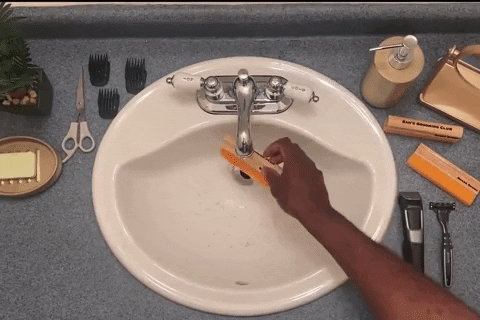 a person using the tool to effortlessly remove hair from the sink