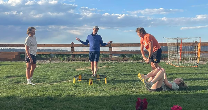 People enjoying a relaxed game of Spikeball on a grassy field, dressed casually and having a blast.