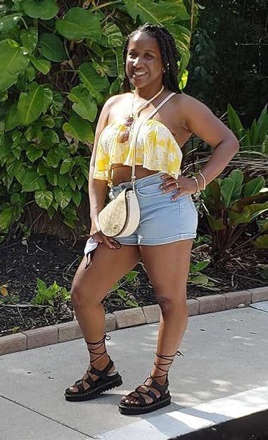 The reviewer is pictured wearing a stylish pair of black sandals.