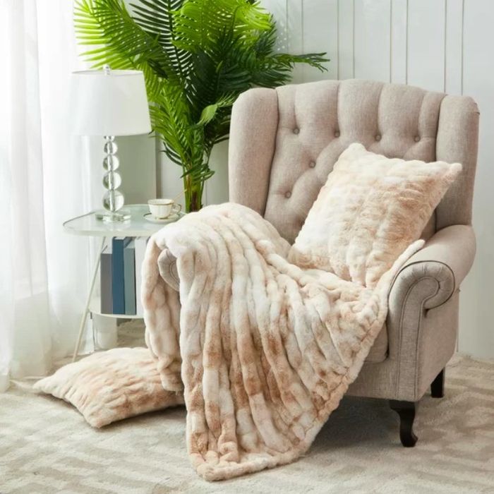 Faux fur draped elegantly over the back of an armchair, offering a plush touch to any room.