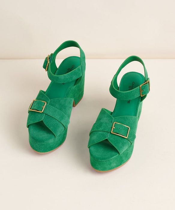 Two green suede platform sandals featuring ankle straps and gold buckles, elegantly displayed on a neutral backdrop.
