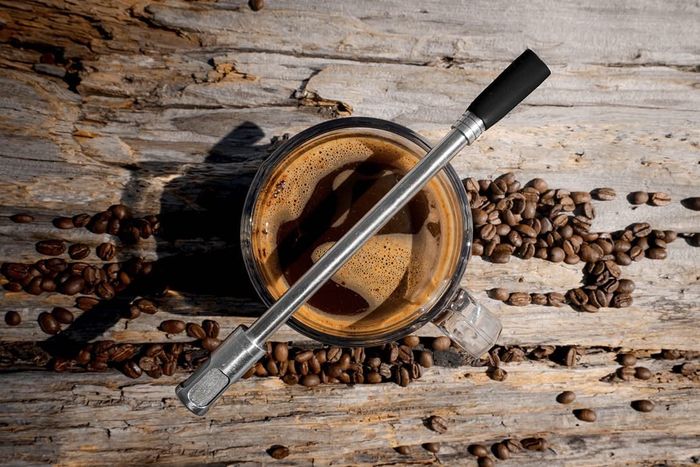 The straw is shown resting on top of a coffee-filled mug.