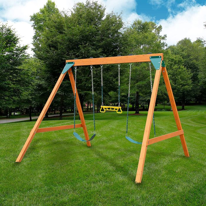 A wooden swing set featuring two swings and a hanging bar in the center.