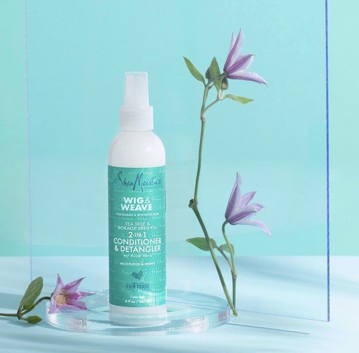 A bottle of conditioner and detangler adorned with purple flowers