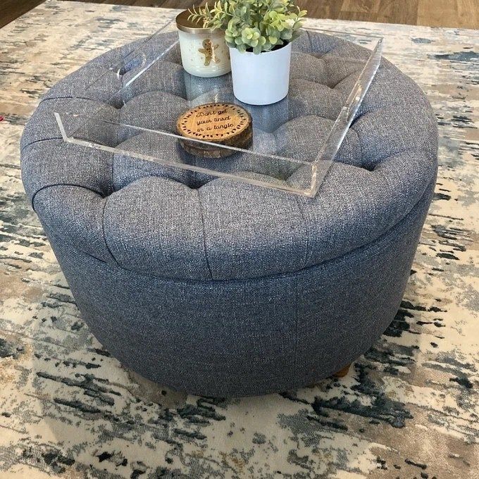 A gray ottoman topped with a sleek tray.
