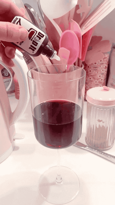 A Mytour editor is shown adding drops to a glass of red wine.