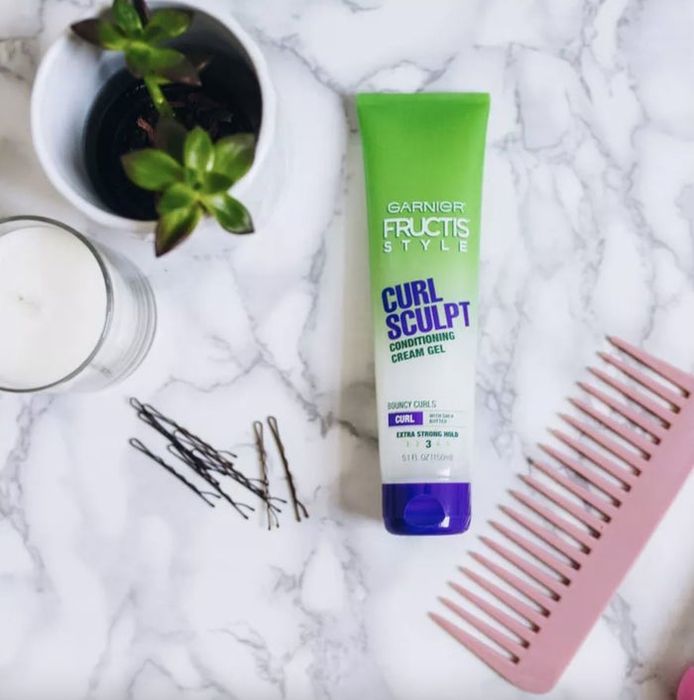 A tube of conditioning cream gel, a wide-tooth comb, bobby pins, and a flower pot